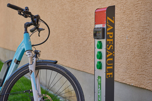 Ein E-Bike steht an einer Ladestation für Fahrräder.