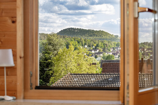 Blick aus einem offenen Fenster auf ein Bergplateau
