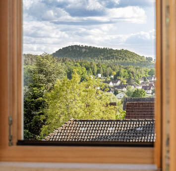 Blick aus einem offenen Fenster auf ein Bergplateau