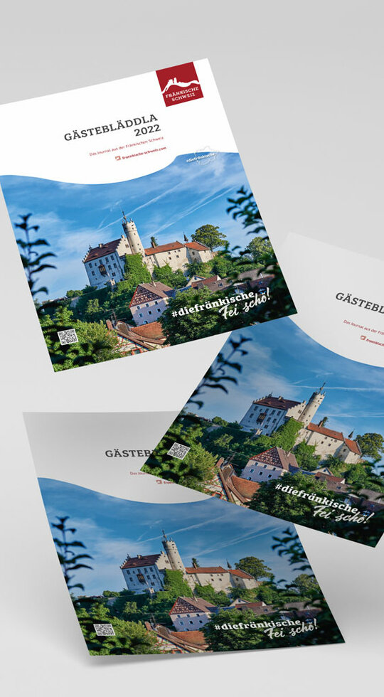 Drei fliegende Titel der Broschüre mit roten Logo und Bild der Burg Gößweinstein.